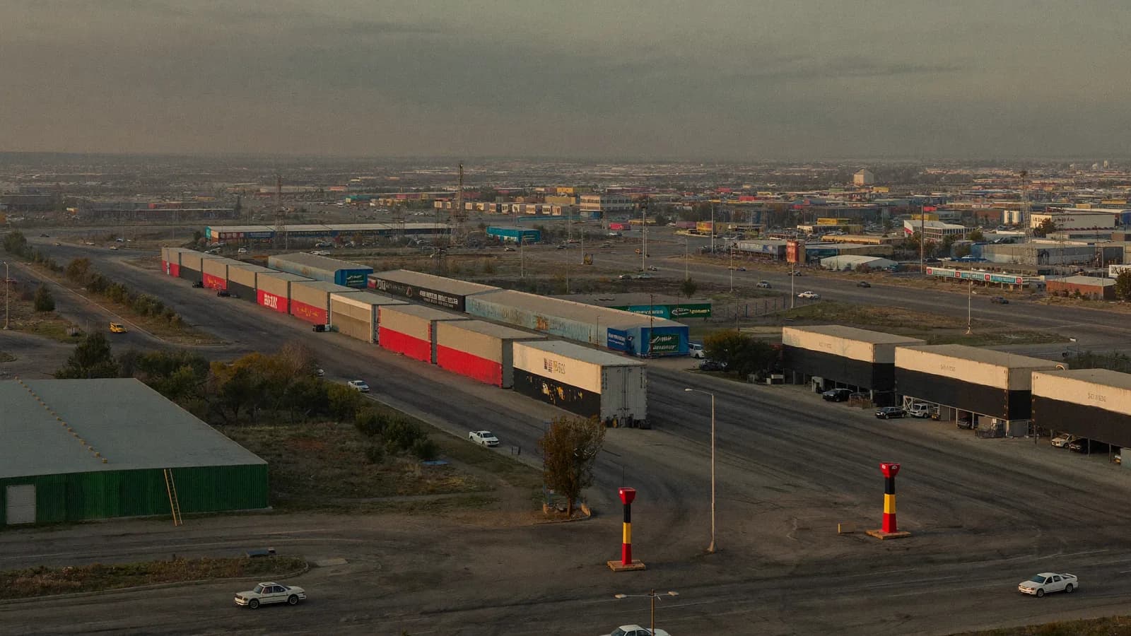 Terminal ferroviaria de mercancías y naves logísticas al atardecer vistas desde el aire
