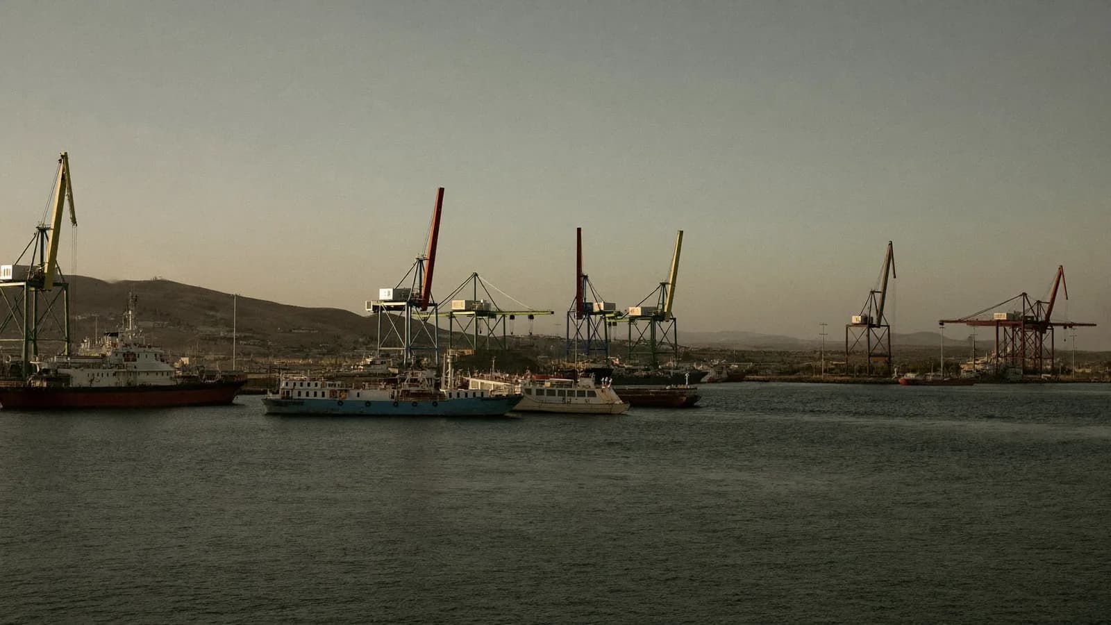 Puerto marroquí a última hora de la tarde con barcas y grúas al fondo