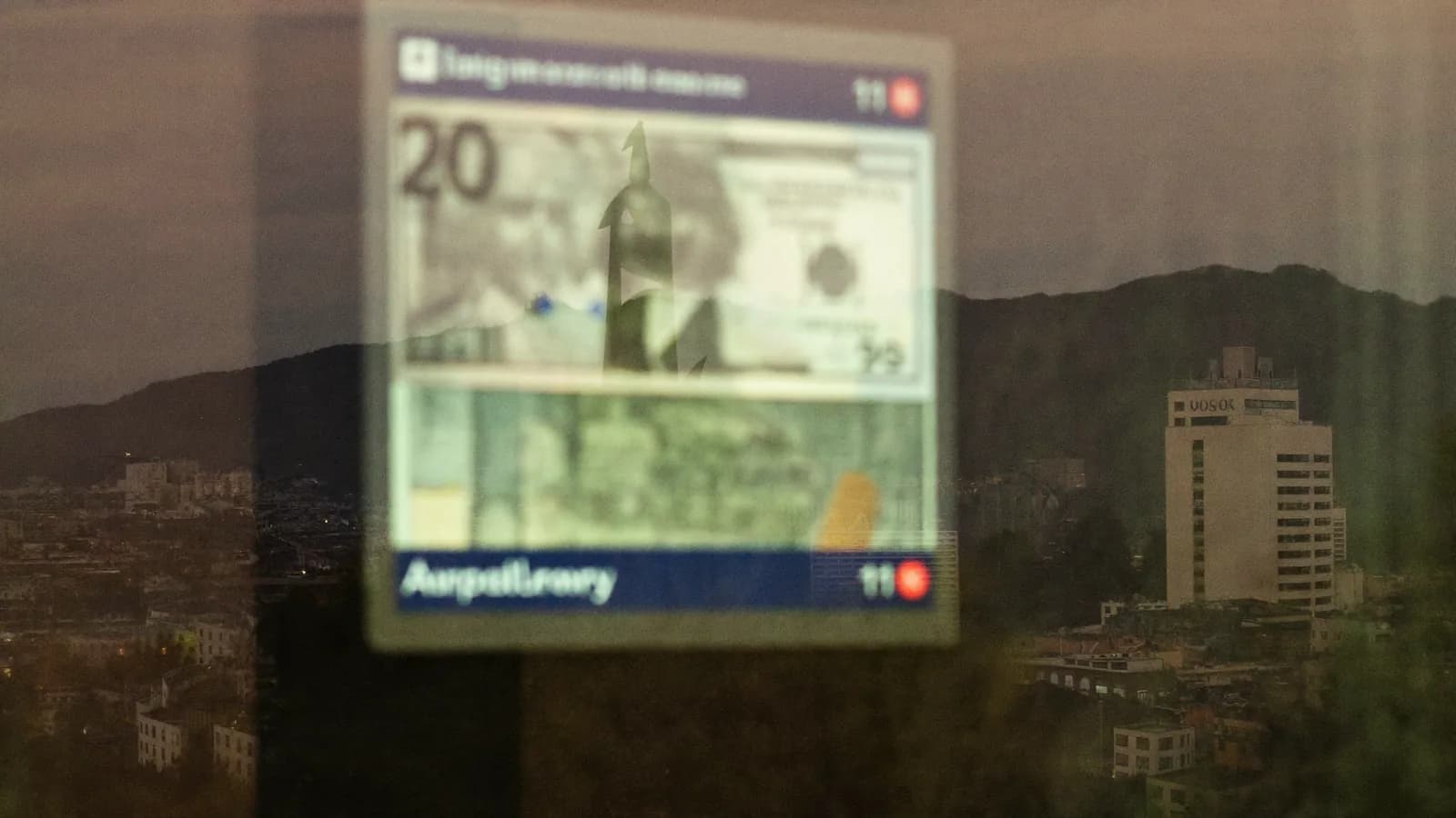 Reflejo de un panel de divisas sobre el cristal de una oficina al anochecer